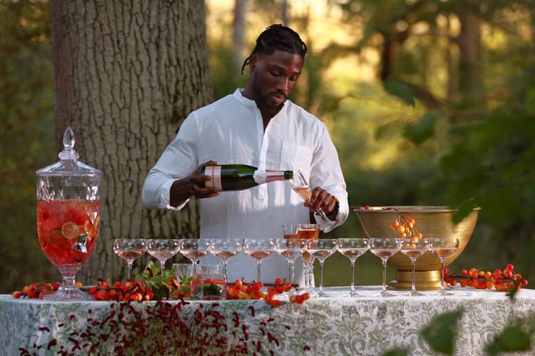 Barman pouring Champagne at an outdoor event.